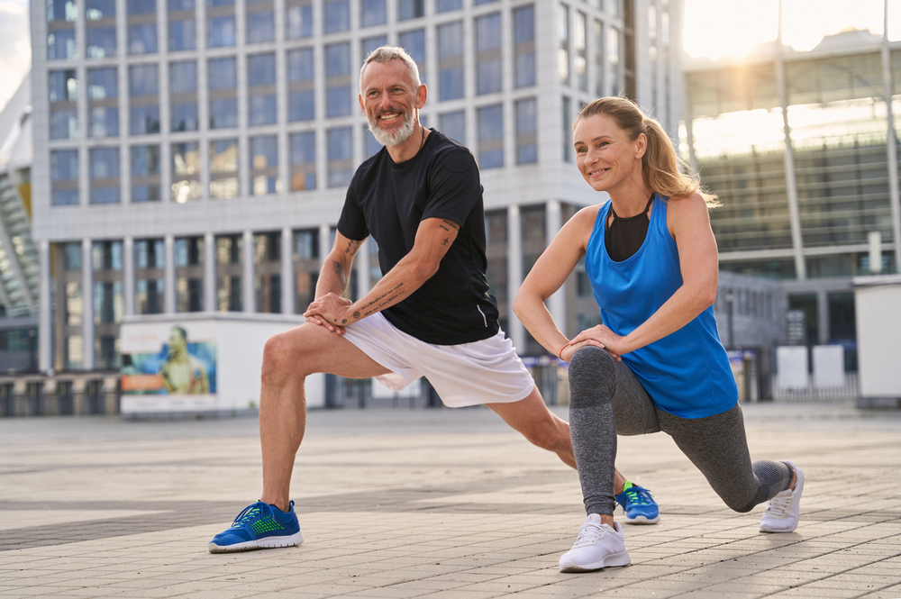 Older man and woman performing lunges together, promoting flexibility and joint health supported by chiropractic care – Chiropractor in Manahawkin, NJ.