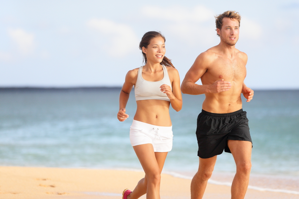 Active Wellness and Recovery – Massage in Manahawkin Fit couple jogging along the beach, highlighting the benefits of regular massage therapy for improved performance and joint recovery – Massage in Manahawkin.